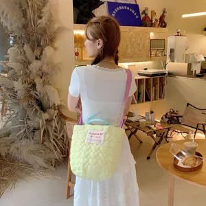 Vue détaillée arrière d'un sac cabas matelassé jaune avec des motifs de cœur