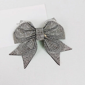 Close-up of sparkling white rhinestone bow hair clip with luxury crystal inlay design