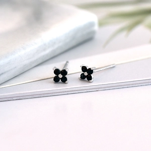 Macro view of S925 sterling silver studs featuring black zircon in a four-leaf clover design
