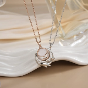 Close-up of rose gold and silver couple necklaces with micro-inlaid stones on silk