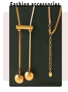Detail of 18K gold plated hollow bead tassels and snake chain on a long necklace