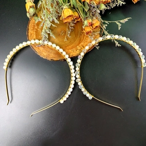 Detail von weißen Perlen und schimmernden Kristallperlen auf goldenen Haarbändern