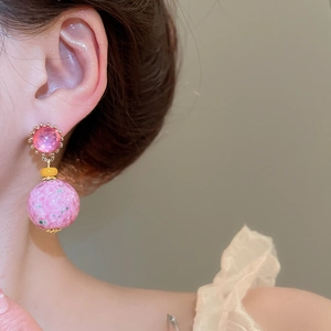 Detail view of vintage resin round drop earrings with pink marble texture on a model