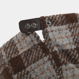 Detailed back view of vintage plaid newsboy hat showing leather strap and metal buckles