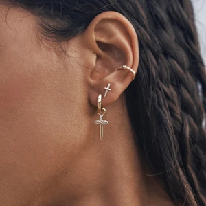 Detail of gold-plated S925 sterling silver hoop earrings with cross and star charms