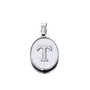 Close-up of oval stainless steel pendant with letter T on white shell inlay