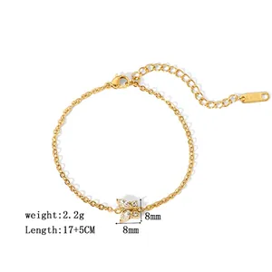 Détail macro d'un bracelet en acier inoxydable plaqué or 18K avec pendentif papillon en cristal