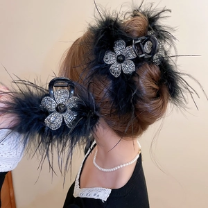 Gros plan d'une pince à cheveux en plumes noires avec strass brillants et fleur de luxe