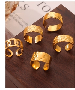 Detailed view of five distinct gold-plated titanium rings with diverse geometric textures