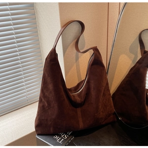 Close-up of brown suede hobo bag featuring smooth leather straps and quality stitching