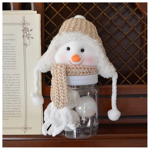 Close-up of snowman storage jar with beige knit hat and transparent body for candy