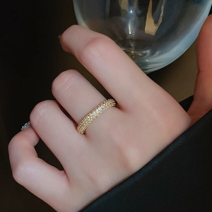 Close-up of gold-plated twisted ring with pavé cubic zirconia worn on a finger