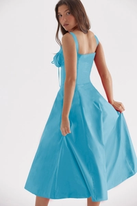 Detail view of the back tailoring and elegant draping of the light blue camisole dress