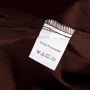 Détail de l'étiquette d'entretien 100% polyester sur un vêtement marron foncé