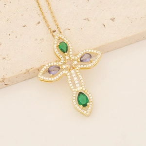 Close-up of 18K gold plated cross necklace with green, purple and clear zircon stones