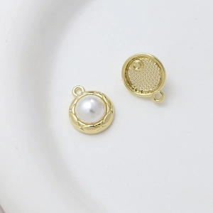 Close-up of golden circular pearl pendant bases with intricate grid texture for DIY jewelry