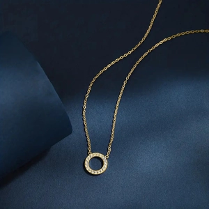 Macro detail of gold circle pendant necklace featuring micro-pave cubic zirconia accents