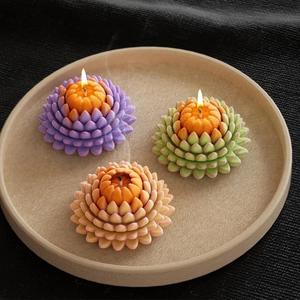 Close-up of succulent lotus shaped candles with detailed multi-layered petals in a tray