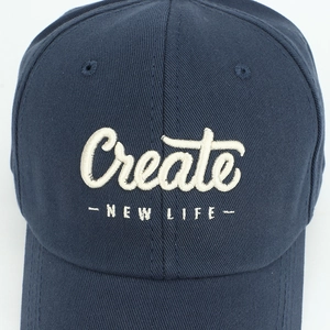 Detailed macro view of white 3D embroidery text on a navy blue cotton baseball cap
