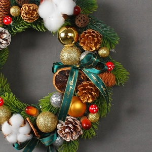 Christmas wreath with pine needles, cones, cotton, and gold balls for wall holiday decor
