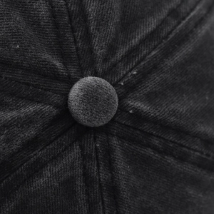 Macro detail of washed denim docker hat showing the stitched top button and fabric texture