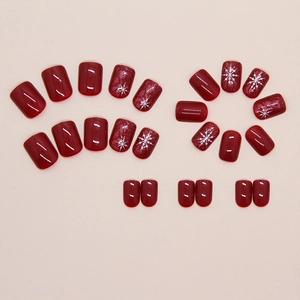 Uñas postizas rojo vino navideñas con copos de nieve blancos y acabado brillante
