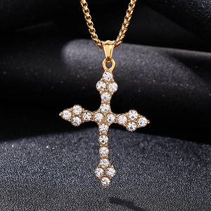 Macro d'un pendentif croix en acier inoxydable doré avec des pierres de zircone blanches