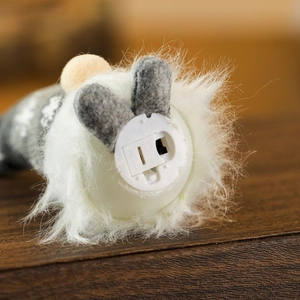 Detail of battery compartment and on-off switch on the base of the glowing plush doll