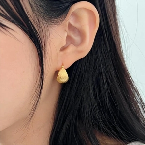 Elegance 925 sterling silver teardrop earrings with brushed gold finish on model