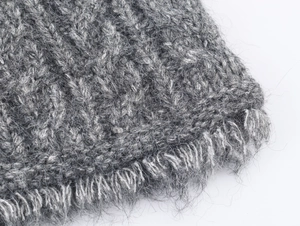 Dettaglio cardigan grigio a trecce con morbida texture in mohair e frange