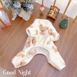 Detail of warm beige plush pet pajamas with cute brown bear prints in a festive holiday setting