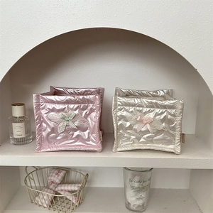 Close-up of heart-quilted square organizers with delicate lace and ribbon bow details