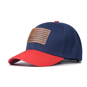 Detail of navy and red baseball cap with American flag brown leather patch and red brim