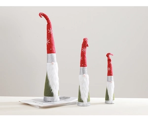 Three-piece set of Christmas gnomes in red, white, and green on a minimalist tabletop