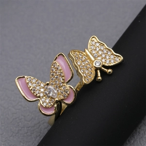 Macro view of gold plated dual butterfly ring with pink enamel and cubic zirconia stones