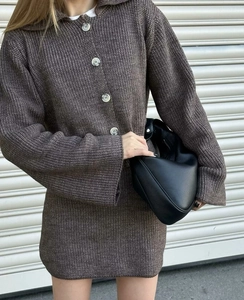 Détail de la maille épaisse et des gros boutons sur le cardigan marron foncé