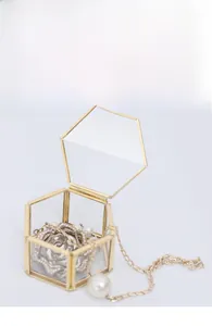 Detailed macro view of an open hexagonal brass and glass jewelry box with gold metal frame