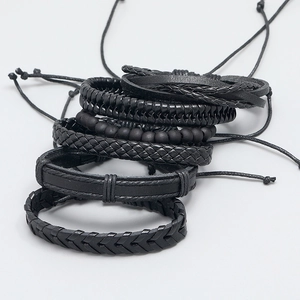 Detail view of black woven leather bracelets and beaded strands with adjustable knots