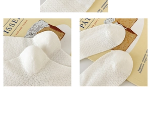 Macro detail of breathable diamond mesh pattern and reinforced heel on white cotton socks