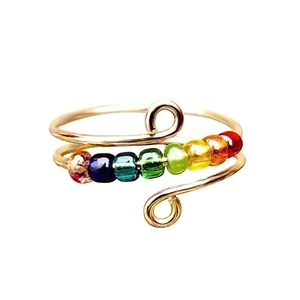 Detalle del anillo ajustable con siete cuentas giratorias de colores en secuencia arcoíris