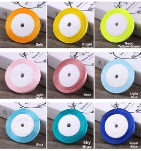 Detailed close-up of 6mm satin ribbons in nine various vibrant colors on white boxes