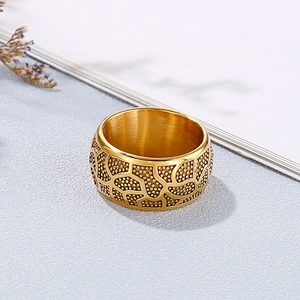Detail of wide gold stainless steel ring with embossed irregular animal skin texture