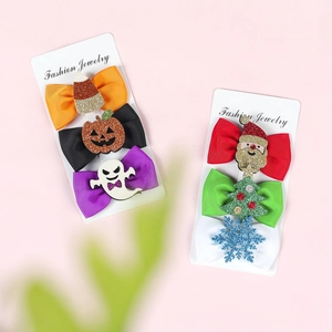Detail of glitter Halloween and Christmas hair clips with festive bow accents