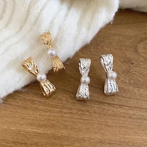 Orecchini a perno con fiocco in metallo e perla in versione oro e argento elegante