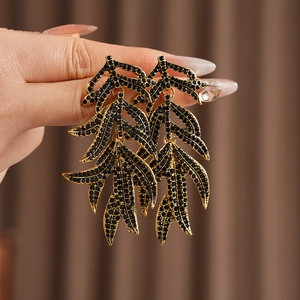Close-up of vintage leaf tassel earrings with diamonds worn on the earlobe