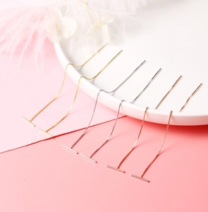 Detailed view of gold, silver, and rose gold tassel earrings on a white porcelain plate