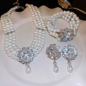 Luxury floral pearl jewelry set featuring clover necklace, bracelet, and drop earrings