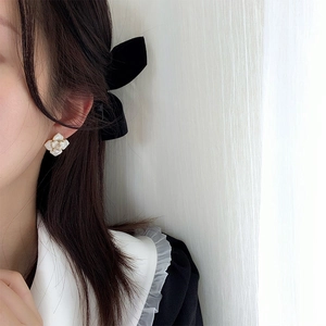 Elegant creamy white floral stud earrings worn by model for a romantic, stylish look