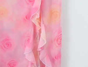 Detailed macro shot of pink rose print chiffon fabric with layered ruffle hem details