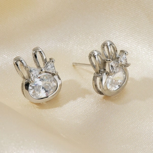 Detailed view of silver rabbit earrings with sparkling zircon crystals on satin